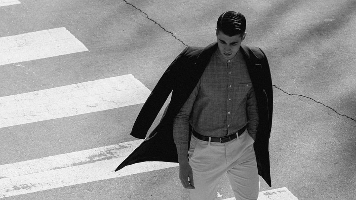 homem vestido de social atravessando faixa de pedestre