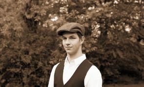 homem de roupa social e boina